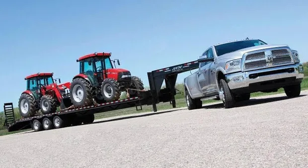 Pickup truck and gooseneck trailer transporting tractors